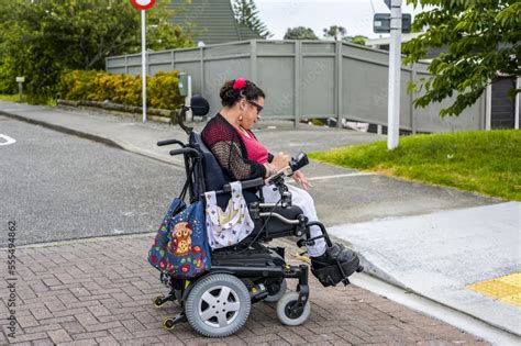 Maori Woman With Cerebral Palsy In A Wheelchair Crossing A Street