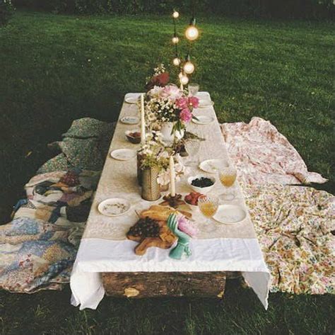 A Picnic Table With Food And Drinks On It In The Middle Of A Grassy Field