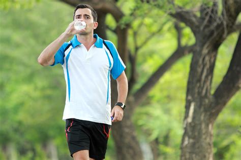 Young Sporty Man Walking While Drinking A Mineral Water Buffalo
