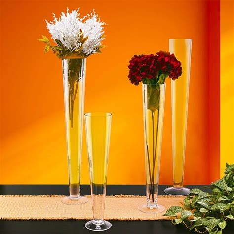 Three Tall Vases With Flowers In Them On A Table