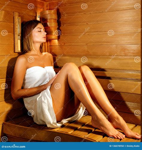 Beautiful Woman Wrapped In White Towel Takes A Wooden Sauna Stock