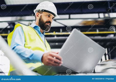 A Portrait Of An Industrial Man Engineer With Laptop In A Factory