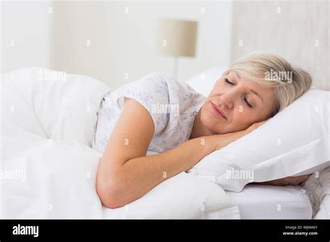 Pretty Mature Woman Sleeping With Eyes Closed In The Bed Stock Photo