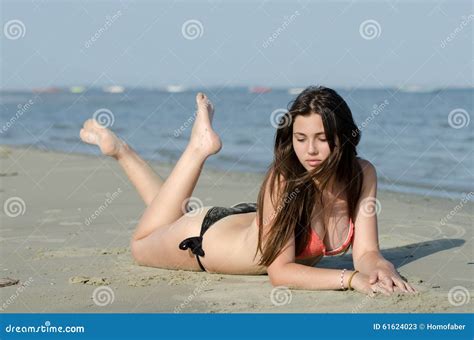 Sexy Body Type In Bikini And Good Looking Lady Lie Prone On Sand Stock