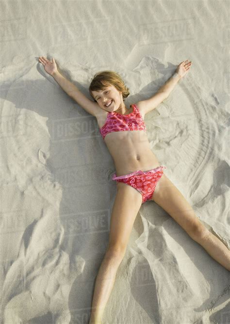 Girl Making Angel In Sand On Beach High Angle View Stock Photo