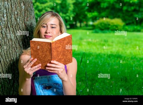Beautiful Girl Reading An Interesting Book In The Summer Park Stock