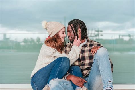 Premium Photo A Young Multiethnic Young Couple In Love Sitting