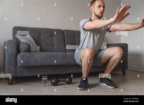 Young Ordinary Man Go In For Sport At Home Real Picture Of Regular Guy Doing Squats With