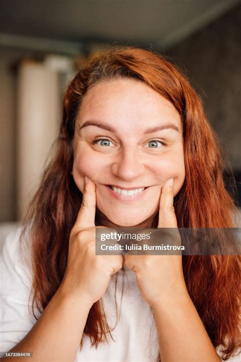 Photo Of Charming Redhead Lady With Fingers Gently Pressing Cheeks