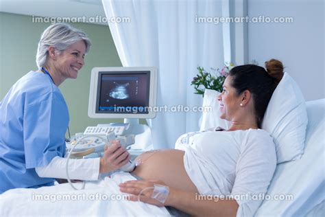 Side View Of Caucasian Female Doctor Doing Ultrasound Scan For Pregnant Woman In The Hospitalの写真