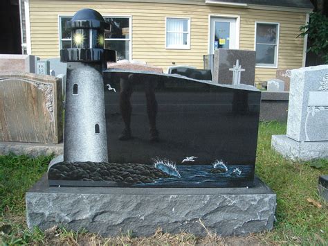 A Grave With A Lighthouse On It In Front Of A House