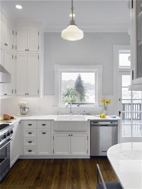 Just give it a bit of a lift with some house plants, wooden accents and a few pieces of darker furniture. white cabinets kitchen grey walls Bright kitchen white ...