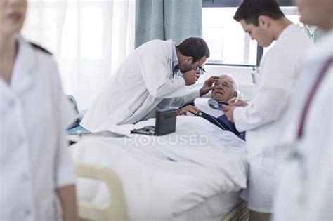 Doctors Examining A Patient In A Hospital — Nursing Staff Hospital