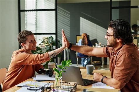 Premium Photo Two Successful Colleagues Giving Each Other High Five