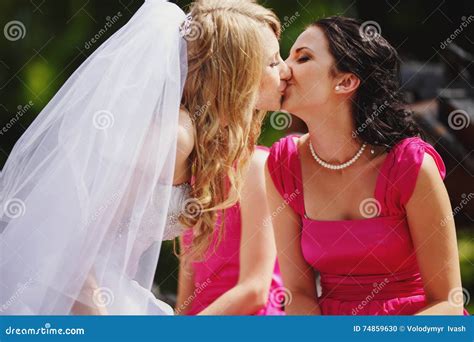 Bride Kisses A Fiance While Her Dress Covers His Legs Royalty Free