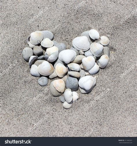Heart Made Of Shells And Pebbles In The Sand Beach