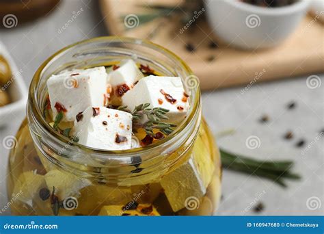 Jar With Feta Cheese Marinated In Oil On Grey Table Closeup Pickled