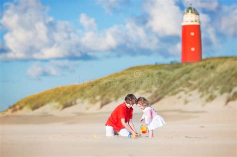 Cute Siblings On The Beach Next To Lighthouse Stock Image Image Of