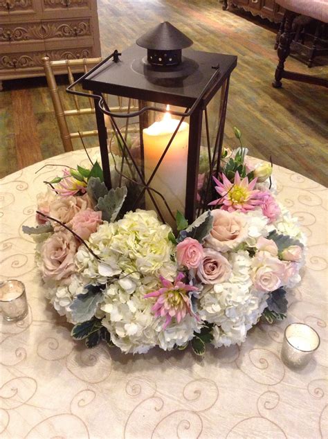 A Beautiful Lantern Centerpiece Surrounded By White Hydrangeas And