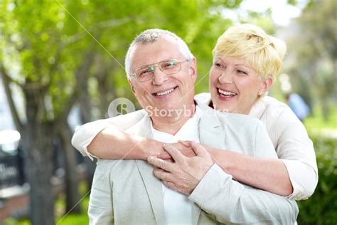 Portrait Of Happy Mature Woman Hugging Her Husband Outside Royalty Free