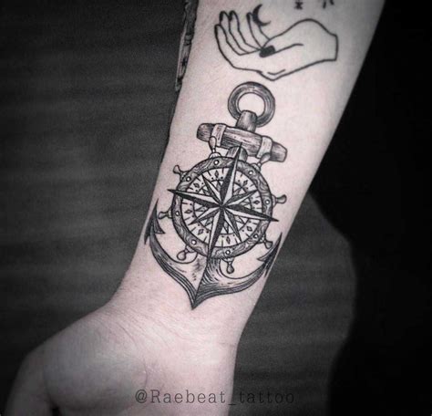 A Hand With A Compass And An Anchor Tattoo On The Wrist Is Shown In