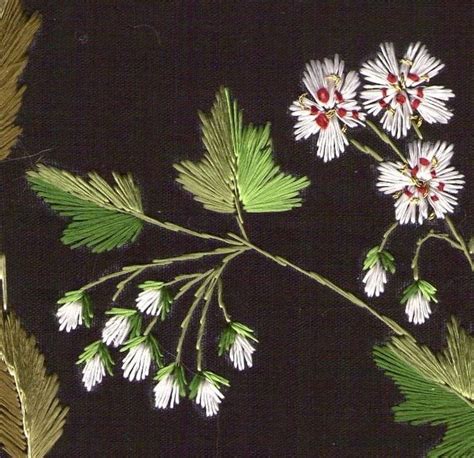 Some White Flowers And Green Leaves On A Black Background