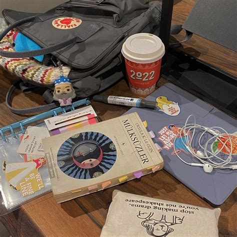 An Assortment Of Items On A Table Including Books Notebooks And A Bag