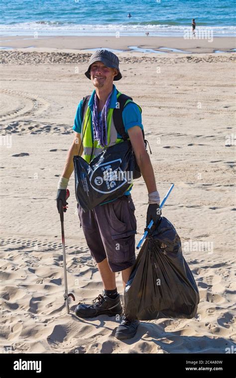 council worker picking up rubbish left behind on the hottest day of the year during heatwave at