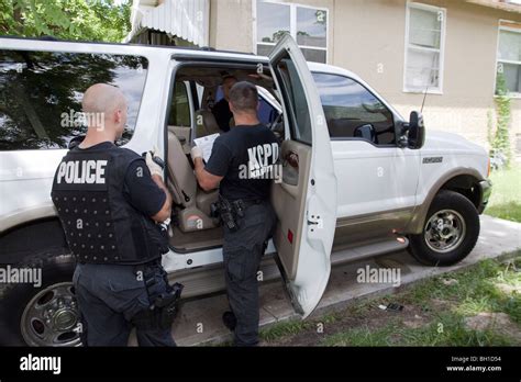 Police Officers From Swat Team Searching Vehicle For Drugs Cash And Weapons Search Warrant