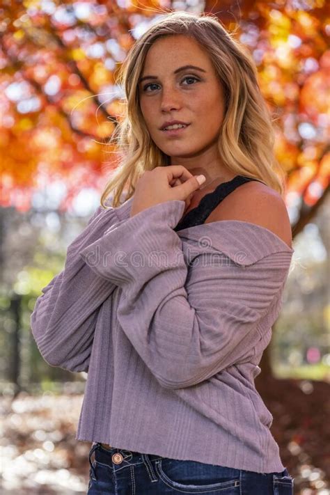 A Lovely Blonde Model Enjoys An Autumn Day Outdoors At The Park Stock