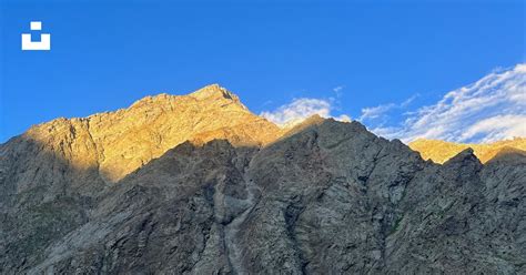 A View Of A Mountain Range With A Blue Sky In The Background Photo