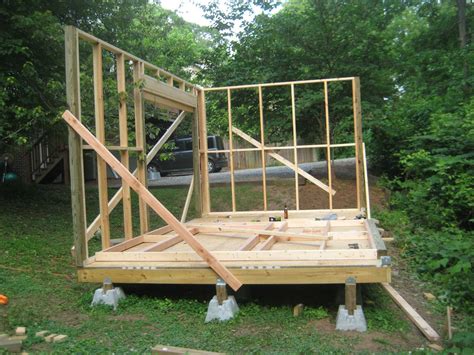 A House Being Built In The Middle Of A Yard With Wood Framing Around It