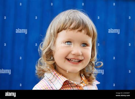 Portrait Of Happy Joyful Beautiful Little Girl Against The Old Textured