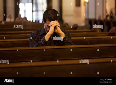 Young Man Praying In Church On The Bench Stock Photo Alamy