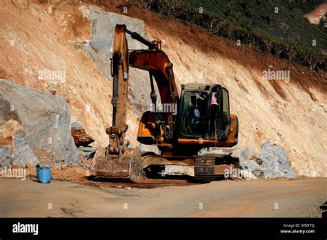 Excavator Working On The Excavation Works Of A Road Moving Rock And