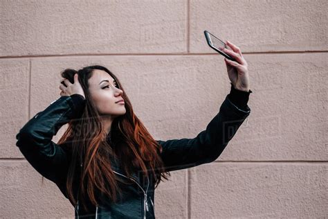 Woman Holding A Mobile Phone Taking A Selfie Stock Photo Dissolve