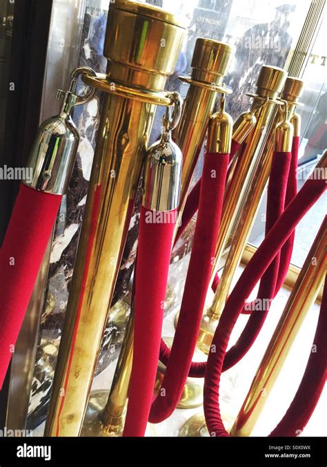 Red Velvet Ropes And Brass Stanchions Signify Exclusivity Stock Photo
