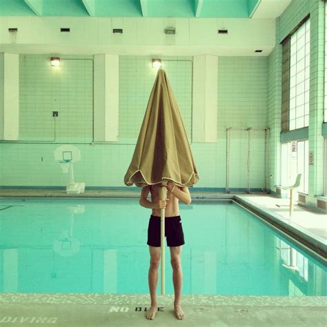 A Woman Holding An Umbrella Over Her Head In A Swimming Pool With No