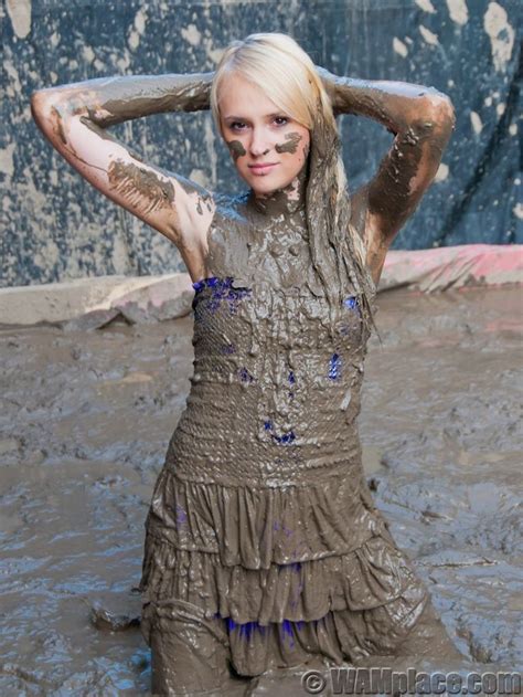 A Woman Covered In Mud Poses For The Camera