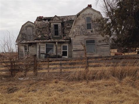 An Old Abandoned House Sitting In The Middle Of A Dry Grass Field Next