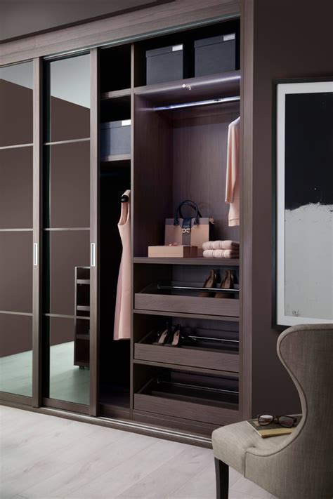 A Walk In Closet With Sliding Glass Doors And Shoes On The Floor Next To It