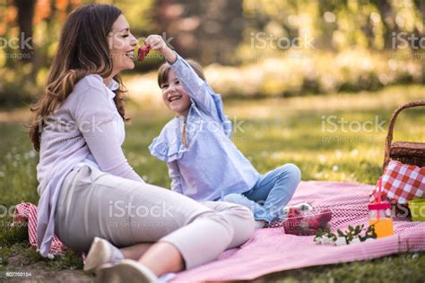 Happy Mother Being Fed With Strawberry By Her Small Daughter Stock