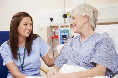 Nurse Sitting By Female Patient S Bed In Hospital Stock Image Image