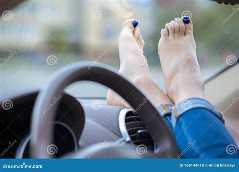 Close Up Of Woman Driver Feet Resting On Car Dashboard Stock Photo
