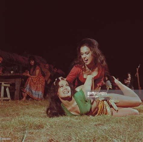 Two Women Laying On The Ground In Front Of A Group Of People One With Her Mouth Open