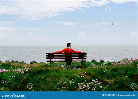 Young Man Sitting On A Bench Looking At The Sea Stock Image Image Of