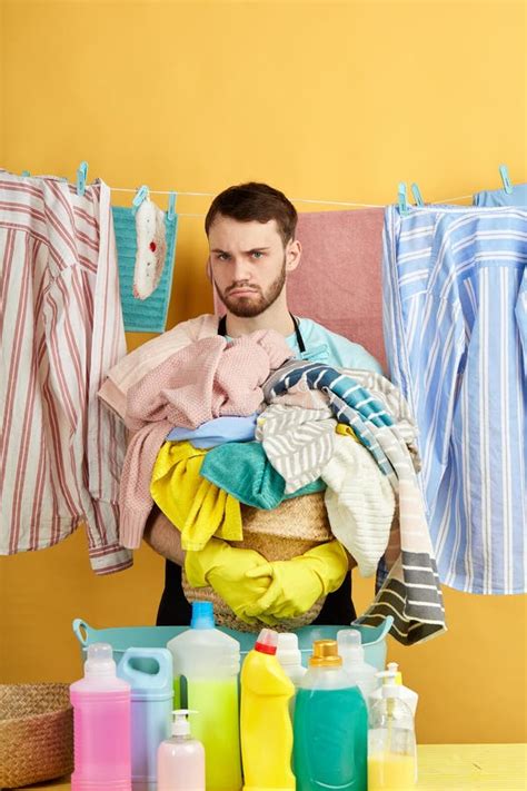 Angry Man With Stack Of Dirty Clothes In Hands Looking At The Camera