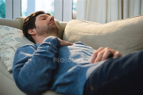Man Sleeping On Sofa In Living Room At Home — Asleep Real Life Stock