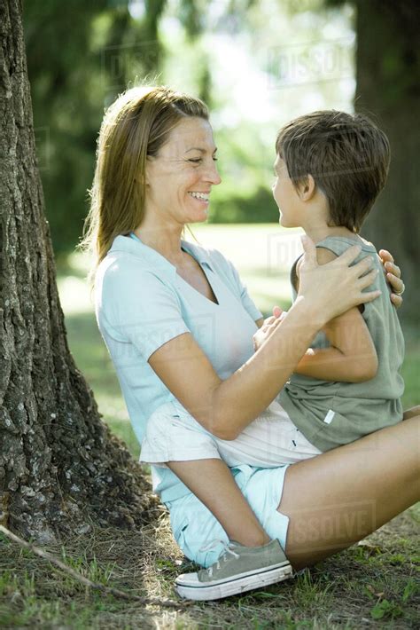 Mother And Son Outdoors Boy Sitting On Woman S Lap Stock Photo Dissolve