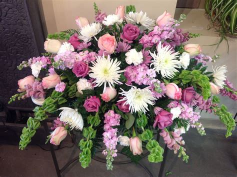 very feminine casket spray filled with fuji mums roses and snap dragons casket flowers grave